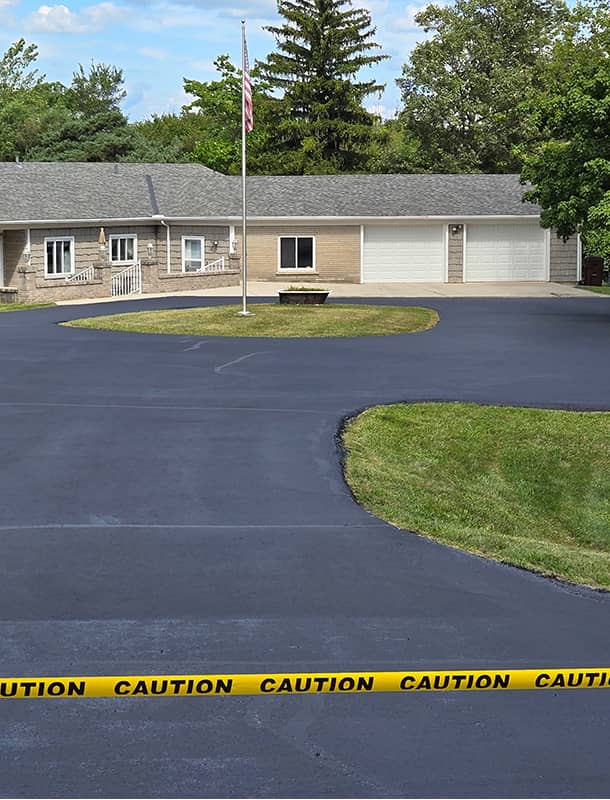 Freshly sealed circular driveway drying at a Bellefontaine, OH home