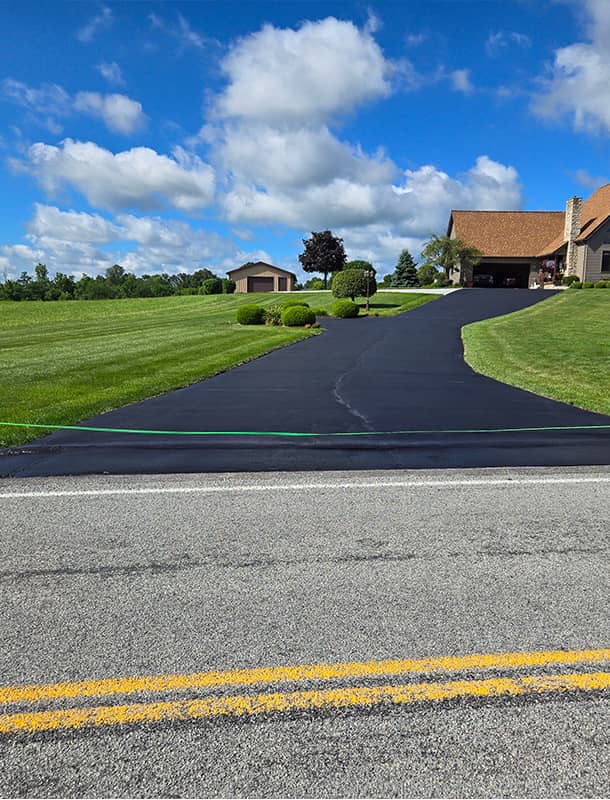 Long freshly sealed driveway leading to a country home in Milford Center, OH
